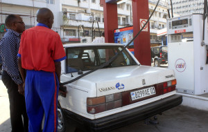 Un pompiste  (en bleu rouge),  emprovisionnant un client  en carburant dans une station service à Kinshasa. Radio Okapi/Ph. John Bompengo